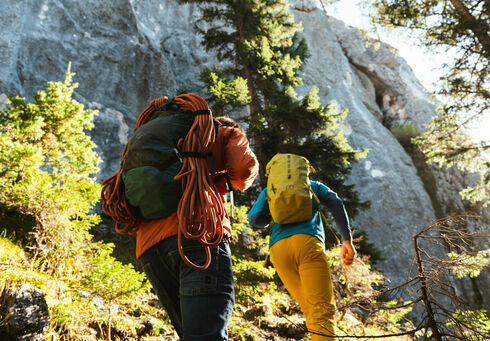 Climbing basic: Tageskurs Felsklettern Zwei Kletterer wandern durch einen Wald zur Grauwand