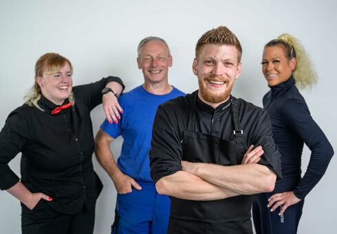 Ein Gruppenfoto mit einer Kellnerin, Seilbahnmitarbeiter, Koch und Reitlehrerin der Region Achensee.