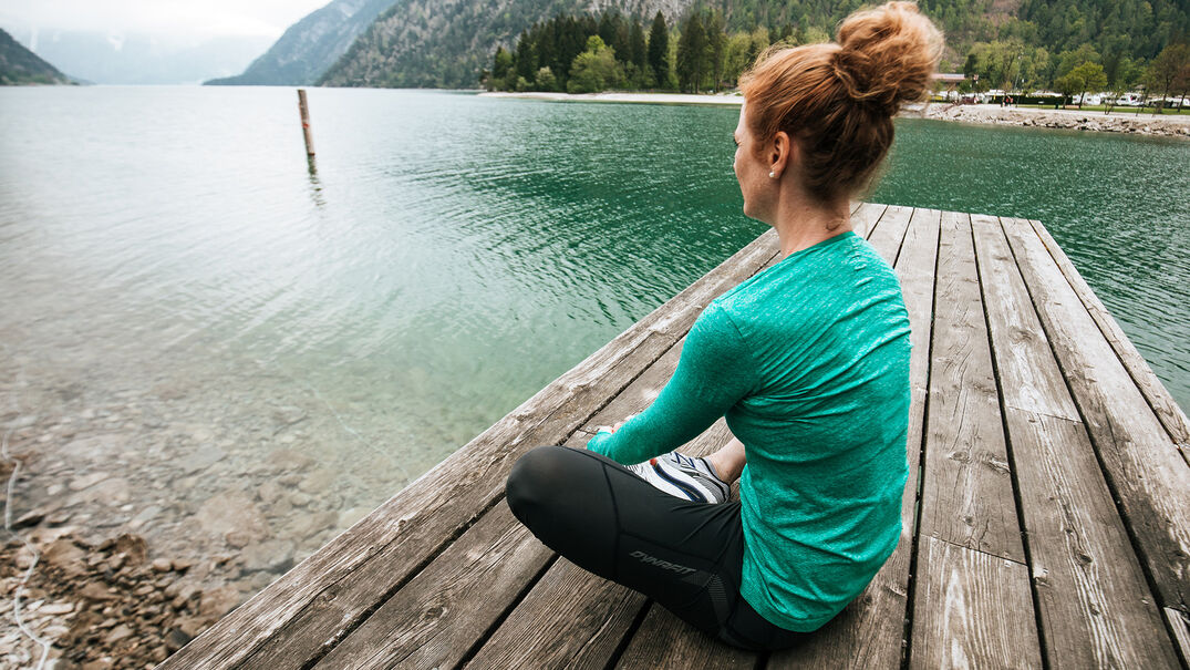 Dehnungsübungen am Achensee Dehnungsübungen machen & den Blick auf den See & den Alpen Caravan Park genießen.