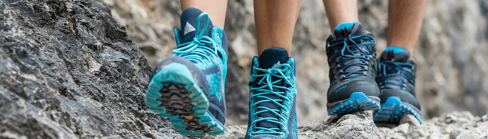 Zwei paar Füße gehen über einen steinernen Weg.}