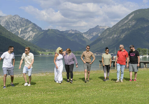 Ein Freundeskreis genießt das Seeufer in der Region Achensee im Sommer.