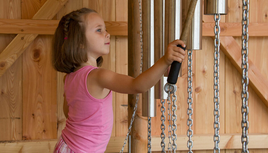 Der Wusel-Seeweg am Ufer des Achensees zwischen Maurach und Achenkirch ist ein Outdoor-Paradies für Kinder. Hier ist ein Kind an der Klangstation.
