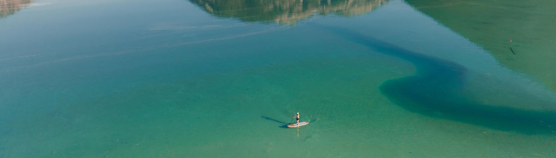 Stand Up Paddleboarding am Südufer des wunderschönen Achensees. Im Hintergrund der Seeberg und der Seekar.}