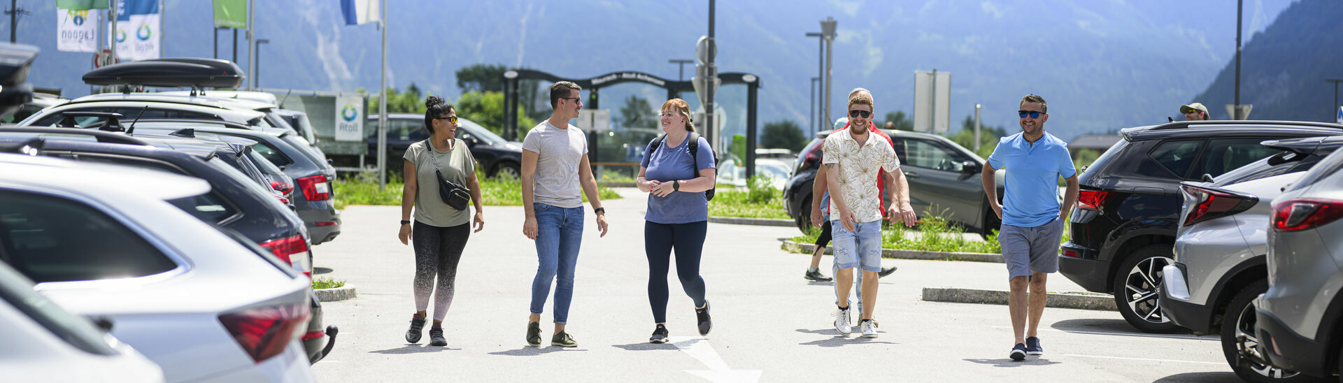 Parkplatz am Achensee Freunde gehen beim Parkplatz des Atoll Achensee gemeinsam zum Auto.}