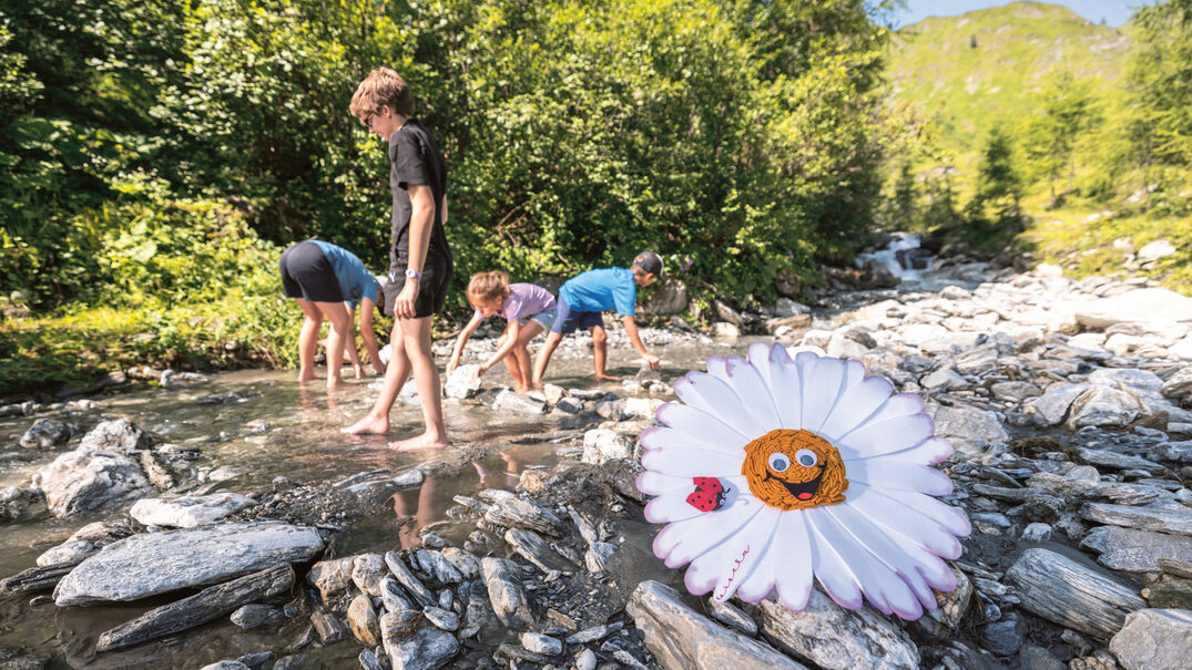 Kinder spielen im Bachbett in der Naturlandschaft der Region Achensee.