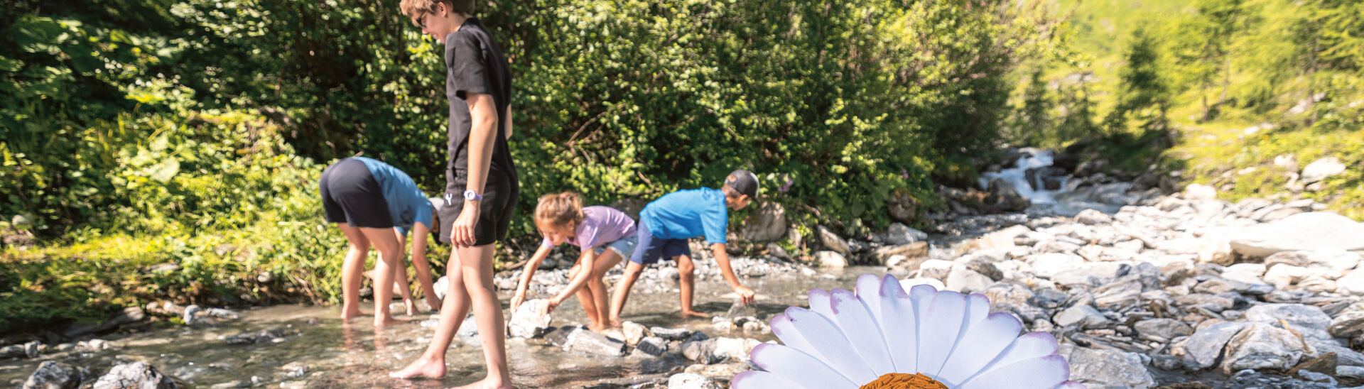 Achensee Kinderprogramm Kinder spielen im Bachbett in der Naturlandschaft der Region Achensee.}