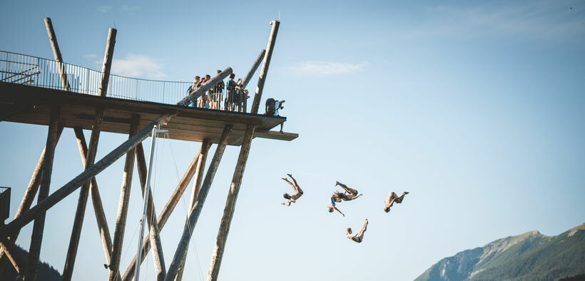 Beim Event Chill & Jump stürzen sich die besten Cliff Diver mit abenteuerlichen Manövern vom Hochsteg in Pertisau in den Achensee.