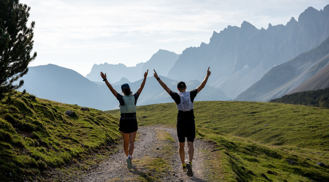 Zwei Teilnehmer des Karwendelmarschs posieren für die Kamera. Im Hintergrund der Naturpark Karwendel.
