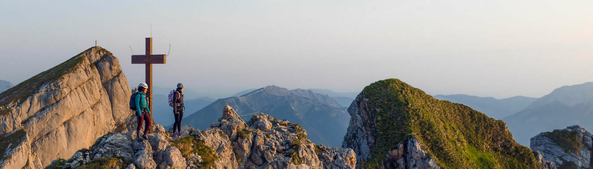 Klettersteig Rosskopf Zwei bergsportbegeisterte Frauen genießen die Morgenstimmung am Klettersteig Rosskopf im Rofangebirge.}