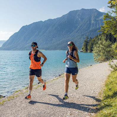 Two runners in beautiful summer weather on the shore of Lake Achensee.