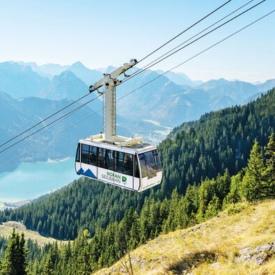 Die Rofan Seilbahn fährt in Richtung Bergstation vor atemberaubender Kulisse.