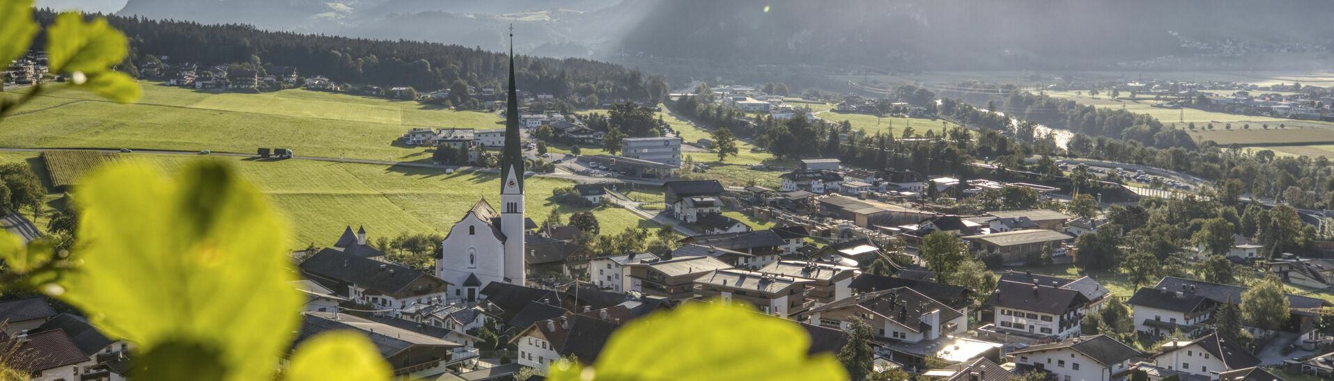 Die Morgensonne lässt das Dörfchen Wiesing hell erstrahlen.}