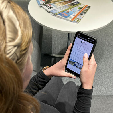 Eine Frau entdeckt den digitalen Urlaubsbegleiter my Achensee auf ihrem Handy.