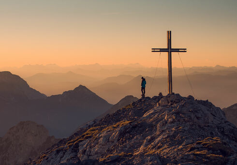 Ein Mann genießt die Zeit auf dem Gipfel des Sonnjochs mit fantastischem Ausblick.