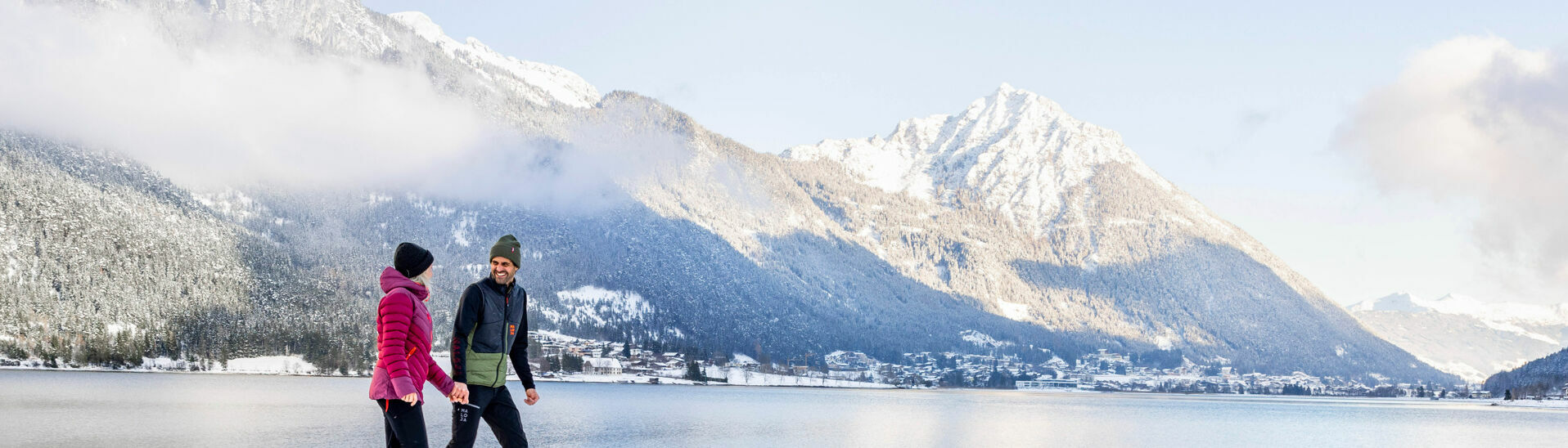 Winterspaziergang in Pertisau am Achensee Ein Paar genießt bei einem Spaziergang die Winterlandschaft am Achensee. Im Hintergrund Maurach und das Ebner Joch.}