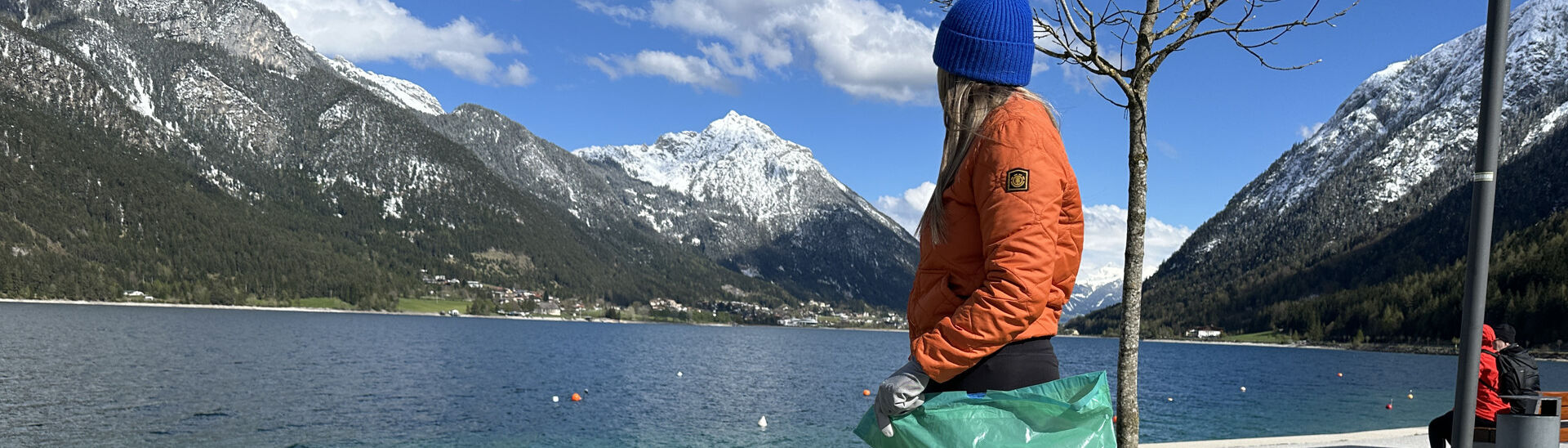 Müllsammeln in Pertisau am Achensee Eine junge Frau sammelt Müll an der Seeuferpromenade in Pertisau.}