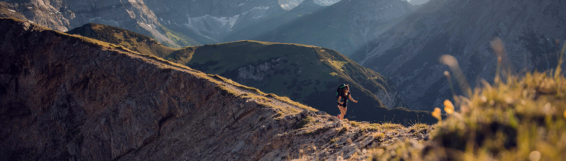 Wandern im Naturpark Karwendel Eine Frau auf dem Weg zum Gipfel vom Sonnjoch bei blauem Himmel.}
