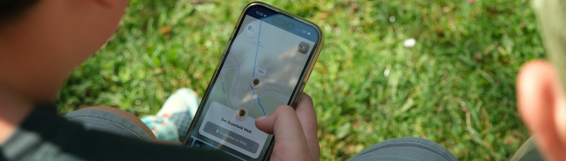 Achensee Natur Erlebnispfad Eine Familie erkundet spielerisch mit dem Handy die wundersame Welt der Fauna und Flora des Naturparks Karwendel auf dem „Achensee Natur Erlebnispfad“.}