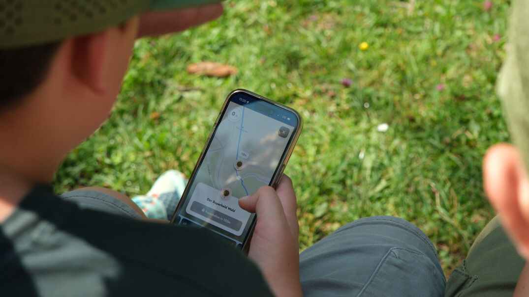 Achensee Natur Erlebnispfad Eine Familie erkundet spielerisch mit dem Handy die wundersame Welt der Fauna und Flora des Naturparks Karwendel auf dem „Achensee Natur Erlebnispfad“.
