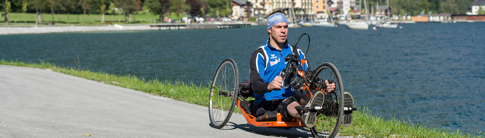 Handbike am Achensee Ein Mann radelt mit seinem Handbike die barrierefreie Route entlang des Achenseeufers in Pertisau.}
