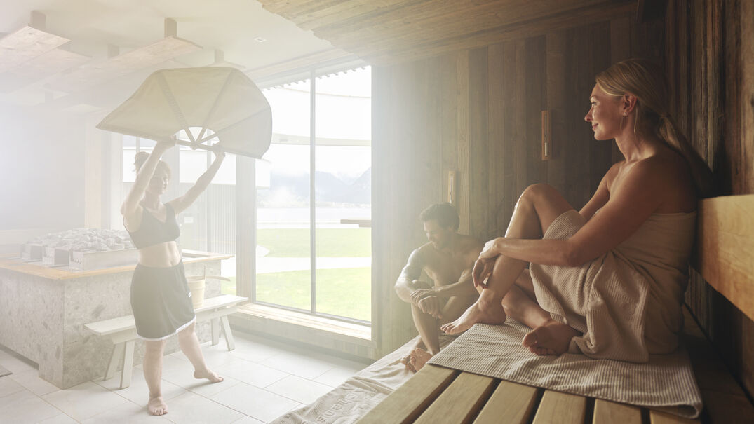 Ein Pärchen genießt den Aufguss im Wellnessbereich des Atoll Achensee.