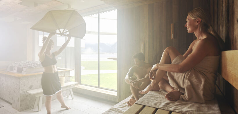 Ein Pärchen genießt den Aufguss im Wellnessbereich des Atoll Achensee.