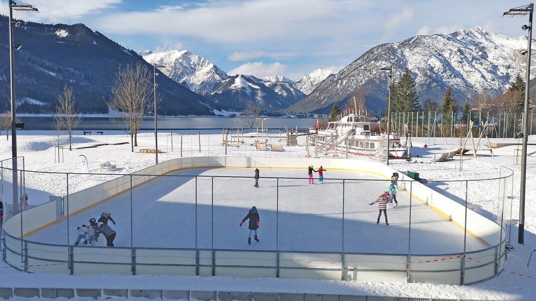 Eislaufen beim Atoll Achensee in Maurach Am Kunsteislaufplatz beim Atoll Achensee in Maurach kann man gemeinsam schöne Kurven drehen.