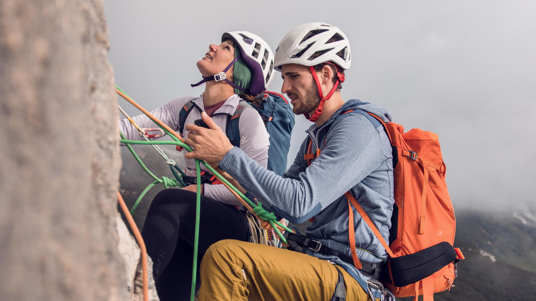 Ein Mann und eine Frau klettern am Südgrat des Gufferts bei nebeligem Wetter.