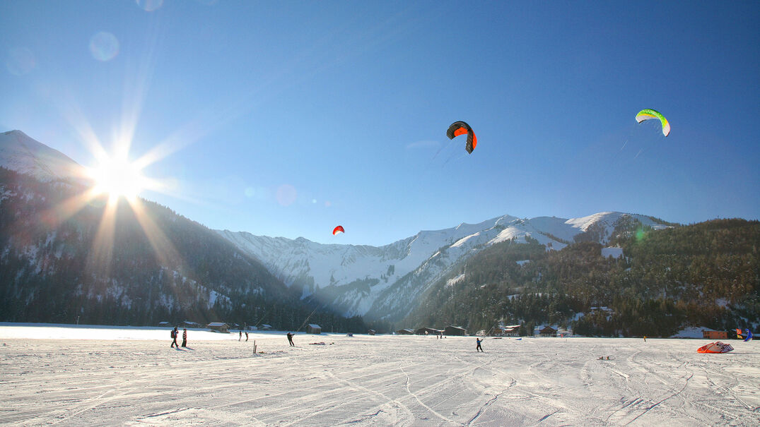 Snowkiten in Achenkirch am Achensee Die Wintervariante des Kitesurfens macht so richtig Laune. Mit einem Kite über den Schnee zu surfen, ist ein Abenteuer, das jeder Sportfan probiert haben sollte.