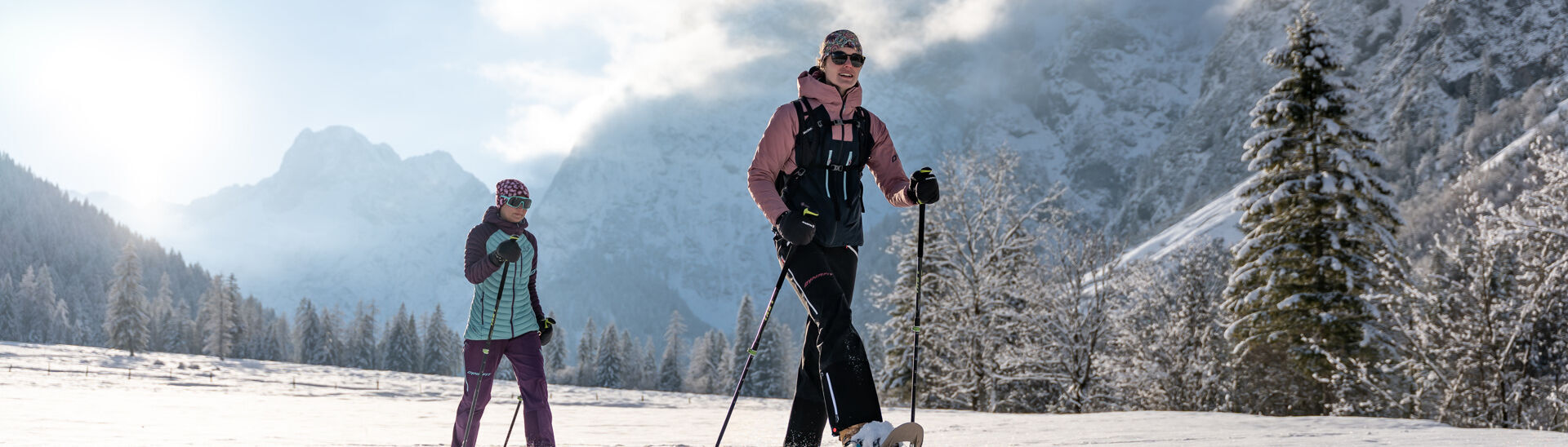 Zwei Freundinnen unternehmen bei herrlichem Wetter eine Schneeschuhwanderung im Falzthurntal im Naturpark Karwendel.}