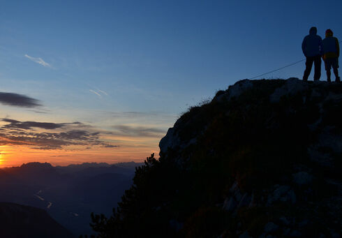 Wanderer genießen den Sonnenaufgang vom Gipfel des Ebner Joch.