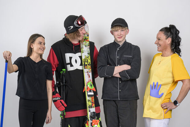 Employees of the Achensee region This photo captures a hotel housekeeper, a skier, an apprentice chef and a care worker holding the Achensee DahoamCard in front of a white screen.