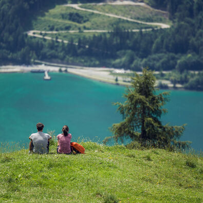 Ein Pärchen genießt den Ausblick auf den. türkis-blauen Achensee vom Rofangebirge aus.