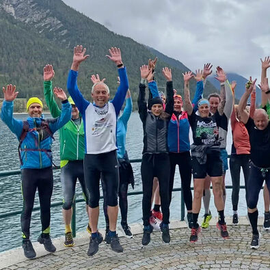 A team photo of a running group at Lake Achensee.