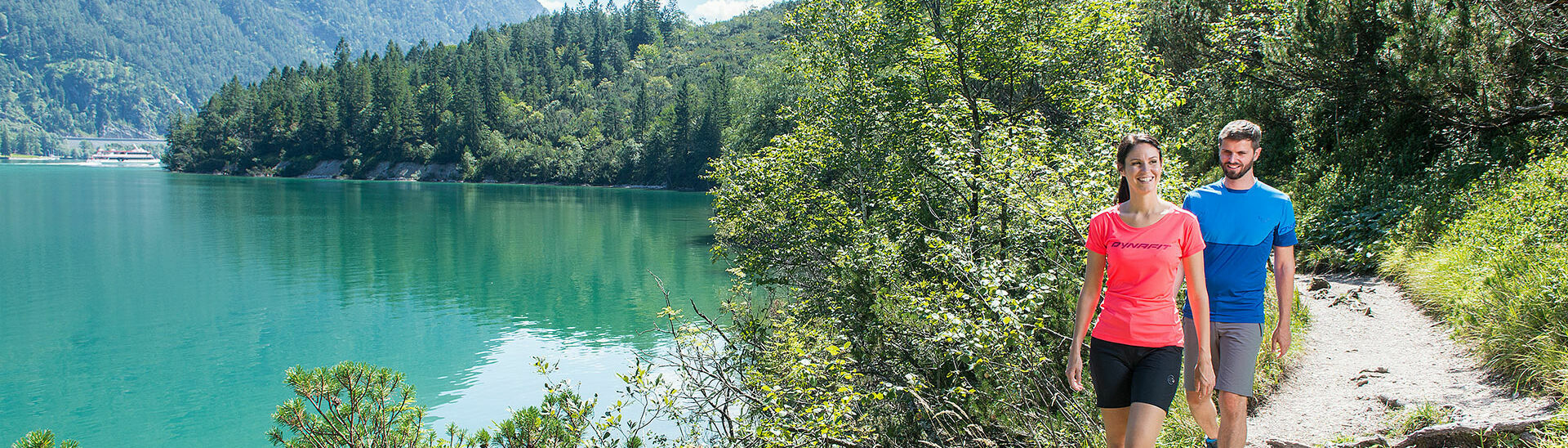 Gaisalmsteig am Achensee Ein Pärchen wandert am abenteuerlichen Gaisalmsteg neben dem Achensee, bei schönem Wetter.}