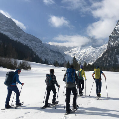 Snowshoe hikers explore the winter landscape at Lake Achensee.