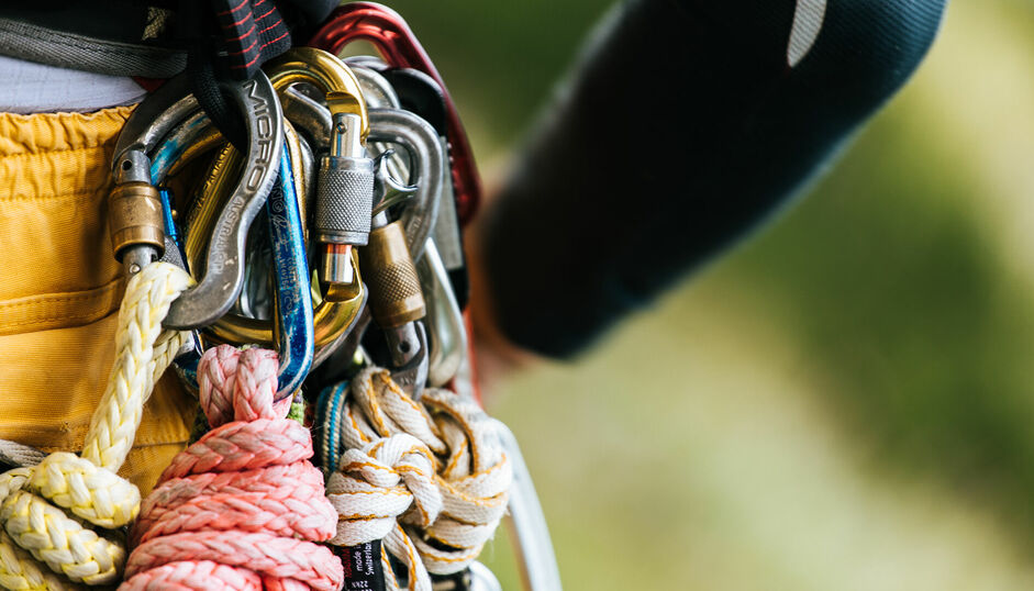 Ein Anhänger an der Hose einer Person mit vielen verschiedenen Karabinern daran.