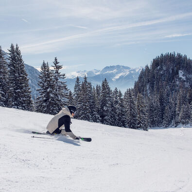 Skifahrer genießen den sonnigen Wintertag auf den gut präparierten Pisten im Rofangebirge.