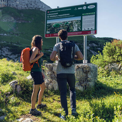 Ein Pärchen erkundet den Naturlehrpfad Rofan und informiert sich über das richtige Verhalten in der Natur. 