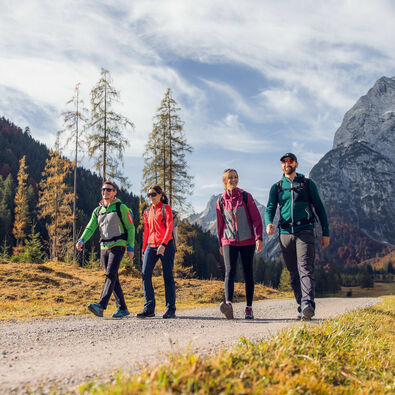 A group of friends take advantage of the beautiful weather for an autumn hike through the colourful Falzthurntal valley in the Nature Park Karwendel.