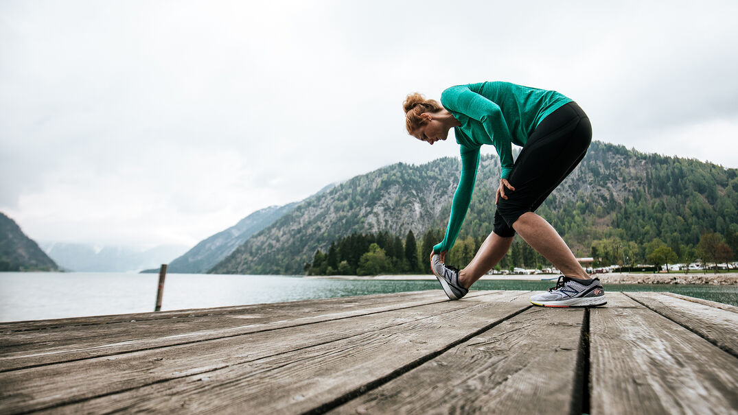 Dehnungsübungen am Achensee Dehnungsübungen machen & den Blick auf den See & den Alpen Caravan Park genießen.