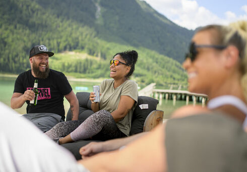 Freunde genießen ihre Freizeit bei einem kühlen Getränk in der BEACH-Bar in Maurach am Achensee.